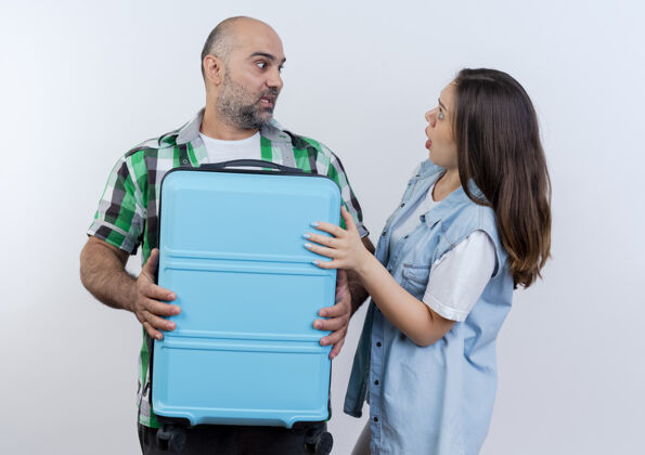 度假令人印象深刻的成年旅行者夫妇男人拿着手提箱 女人把手放在手提箱上 两人互相看着对方旅行者印象看