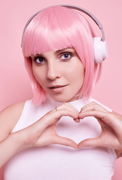 耳机粉红头发的美女肖像在耳机里欣赏音乐聚会女人无线