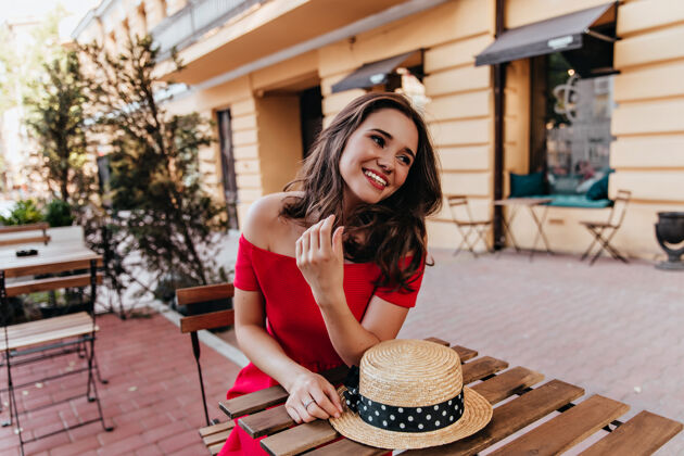 女人幽默的女模特在街上的咖啡馆休息快乐的棕发女孩戴着草帽表达幸福的户外肖像城市快乐散步