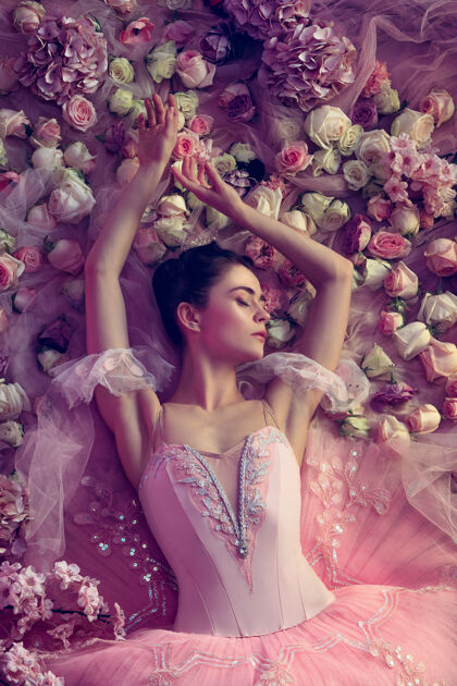舞蹈温暖的夜晚美丽的年轻女子身着粉色芭蕾舞短裙俯瞰四周鲜花环绕珊瑚光下的春天意境和温柔春天的概念 花朵和大自然的觉醒年轻优雅运动