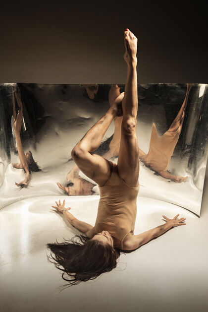 体操温柔年轻 时尚的现代芭蕾舞演员在棕色的墙壁上与镜子 幻觉反射在表面上灵活和运动的魔力创意艺术舞蹈的概念 行动和鼓舞人心全面健美操姿势