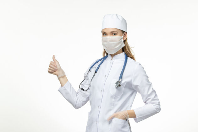 药品前视女医生身穿医疗服戴口罩因冠状病毒上桌淡白色疾病冠状病毒-大流行病毒女性面罩正面