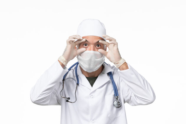 人员正面图：男医生穿着医疗服 戴着口罩 因为柯维德-白墙疾病柯维德-大流行疾病套装视图成人