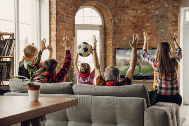 团体兴奋 快乐的大家庭团队一起在家里的沙发上看体育比赛可爱孩子国家