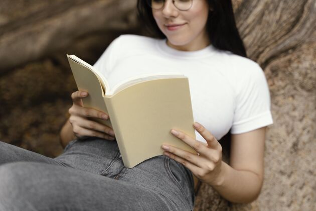 教育年轻女子在户外读一本有趣的书知识分子故事女人