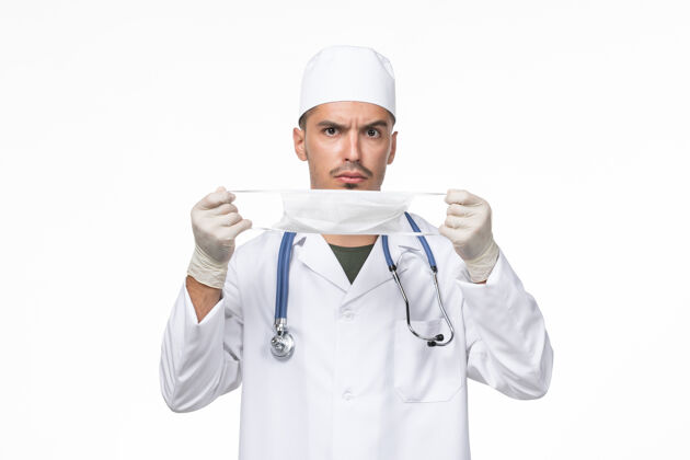 男性正面图：男医生穿着医疗服 戴着防冠状病毒口罩 白墙病毒-疾病大流行疾病正面西装