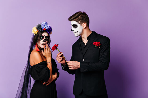 帽子僵尸男人在万圣节向他的女朋友求婚一对相爱的吸血鬼情侣的摄影棚照片骷髅幻想节日