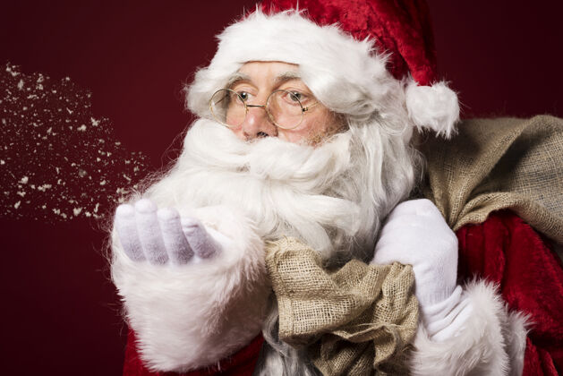 庆祝活动圣诞老人带着一个红色背景的礼盒积极的情绪胡子圣诞老人