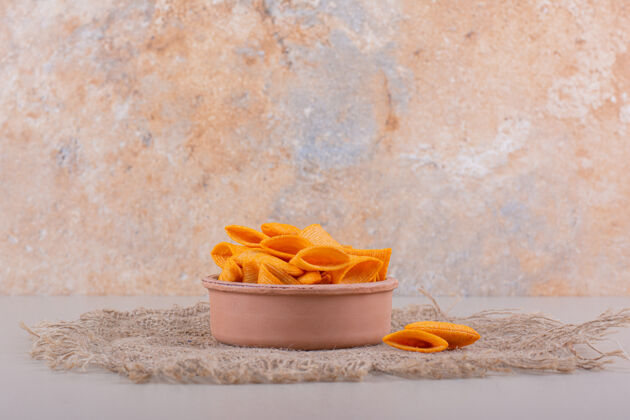 薯条在大理石背景上放一碗三角形脆薯片高质量的照片开胃菜咸烹饪