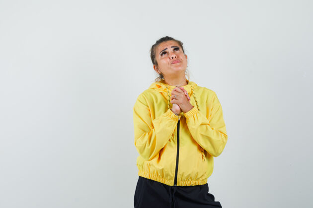 肖像穿着运动服的女人双手合十 做着祈祷的姿势 看上去充满希望 正前方年轻希望微笑