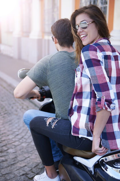 搞笑一对夫妇在城里骑摩托车城市场景假日玩
