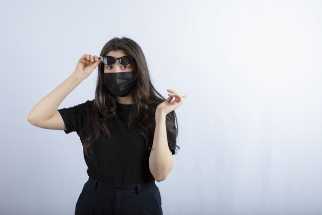 口罩年轻女孩戴着黑色口罩 因为大流行和摆姿势医疗年轻人检疫