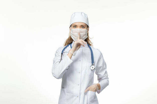 面罩前视女医生穿着医疗服戴口罩因白色办公桌上冠状病毒病冠状病毒-大流行病毒病正面护士佩戴