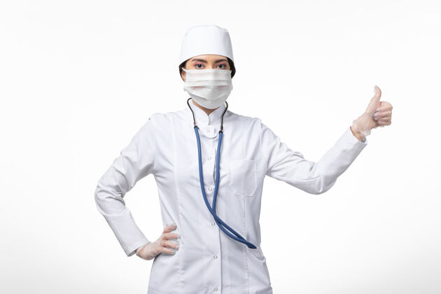 实验室外套前视图：女医生穿着白色无菌医疗服 戴着口罩 因为白色墙壁上有病毒性传染病专业正面病毒