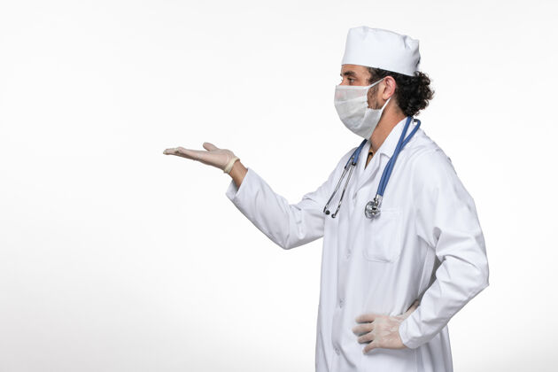 实验室外套正面图身穿医疗服的男医生戴着口罩 以防白墙病毒疾病的传播面罩西装病毒