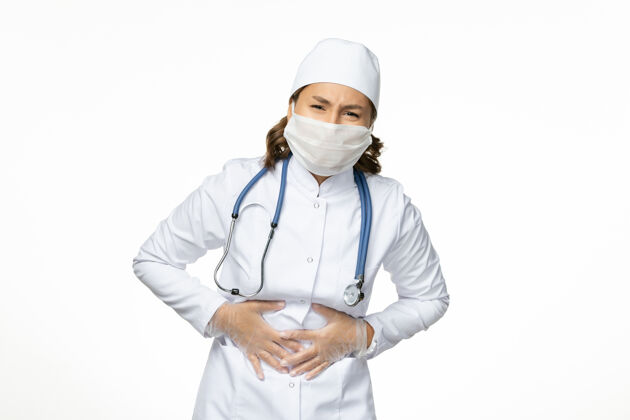 疾病白壁上穿着白色医疗服 戴着胃痛面具的女医生潘多米病毒病药视图病毒面罩