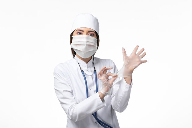 外套正面图女医生身穿白色无菌医疗服 带口罩 因白色桌上有冠状病毒大流行疾病病毒冠状病毒医生套装