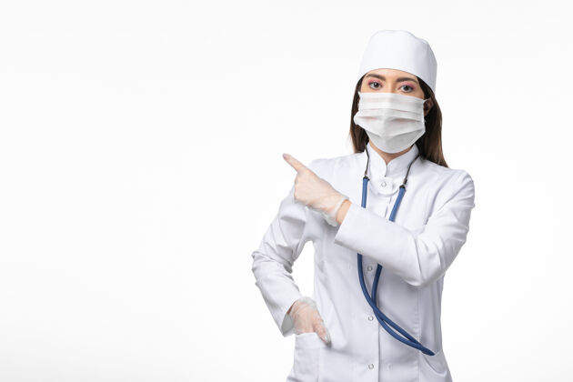 人正面图：女医生穿着白色无菌医疗服 带着口罩 因为柯维德-白墙疾病柯维德-大流行疾病冠状病毒预防人面具