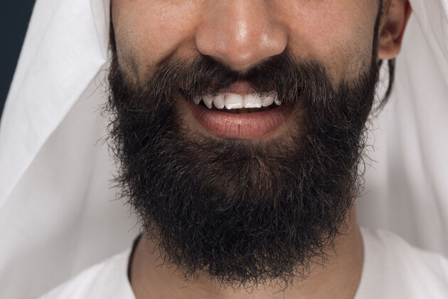 商人深蓝色空间上的阿拉伯沙特商人的特写肖像留着胡须的年轻男模的脸 微笑着表情震惊搞笑