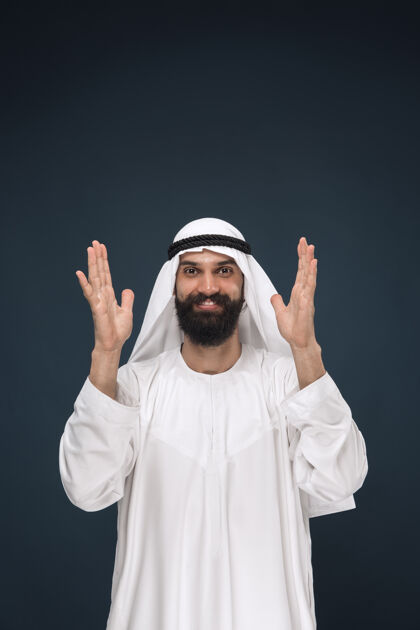 沙特深蓝色空间上的阿拉伯沙特商人半身像年轻男模站着微笑震惊面部东方