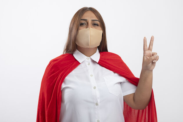 女性高兴的中年女超人戴着医用口罩显示和平姿态隔离在白色面具和平超级英雄