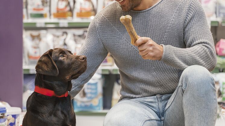 客户可爱的狗和主人在宠物店购买商品销售