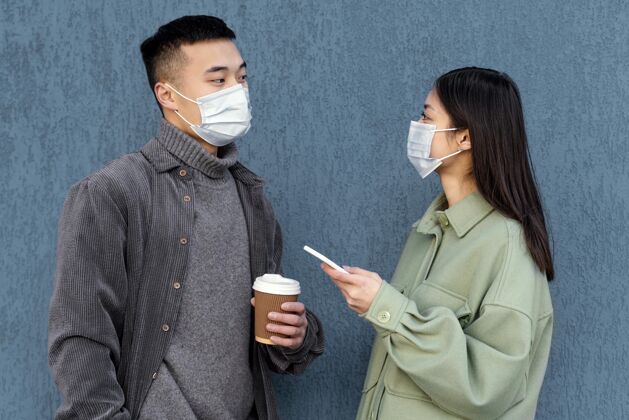 工作室戴着面具的日本年轻夫妇咖啡男人女人