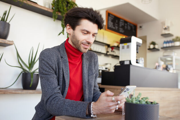 男性年轻迷人的棕色头发的男人坐在城市咖啡馆漂亮胡须积极