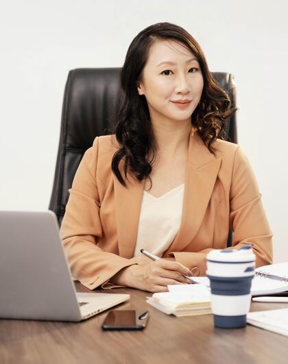 笔记本电脑中等身材的女人在桌子前摆姿势工作团队领导商务女性