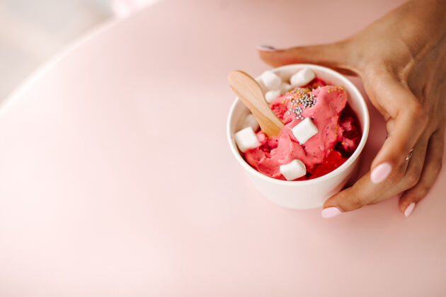 选择性聚焦一个拿着冰激凌杯子的女人的局部视图一个拿着棉花糖享受甜点的女人勺子美味人