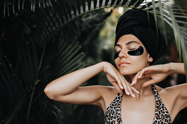 热带站在棕榈树下戴着眼罩的性感女人戴着头巾的美丽女人在自然背景下摆姿势魅力人美丽