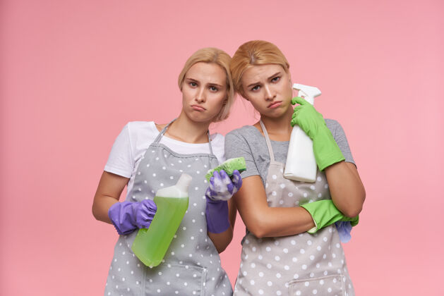 头发年轻的金发可爱的主妇们戴着橡胶手套准备春季大扫除穿双胞胎家务