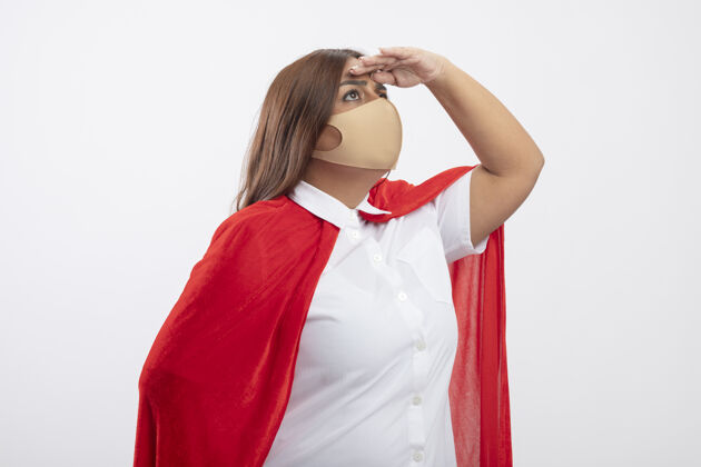 中年想中年女超人戴着医用口罩看着远处用手隔离的白色超级英雄思考手