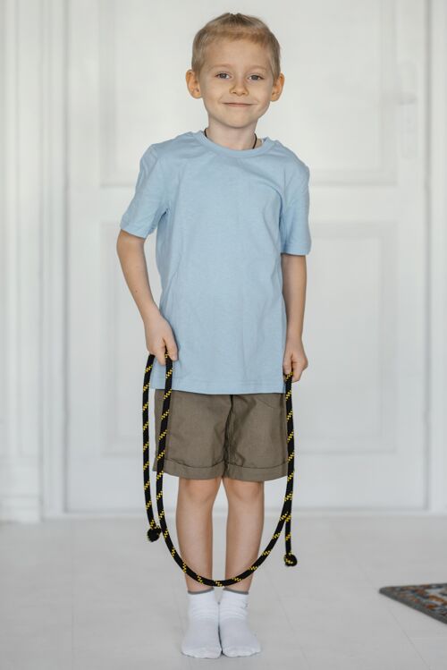 内满脸笑容的小孩拿着跳绳训练私人教练健康