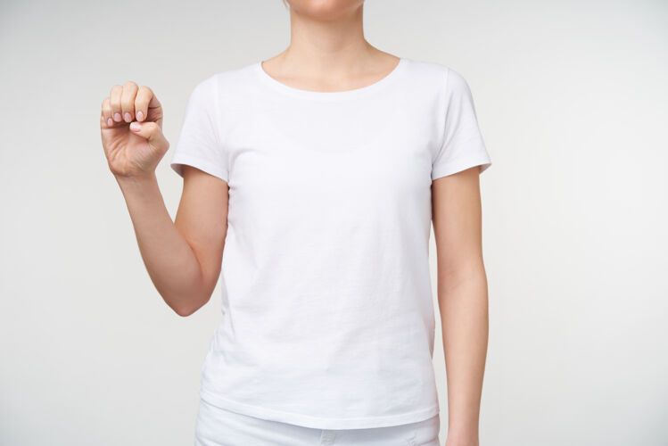 女士摄影棚的照片 年轻的皮肤白皙的女性学习聋哑字母表和形成字母e与提高的手 而站在白色背景的休闲服T恤符号女人