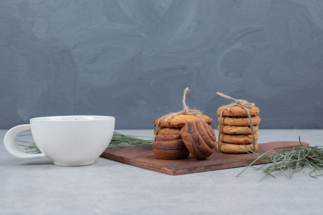 饼干一堆节日饼干和一杯茶放在灰色的桌子上高质量的照片面包房树枝甜点