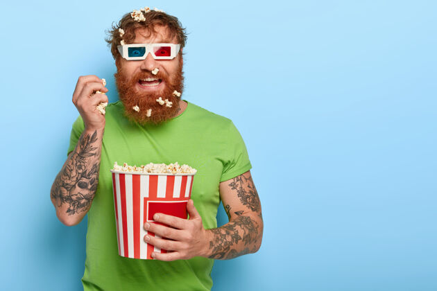 人高兴的红发男人透过电影院的眼镜盯着镜头男娱乐红发