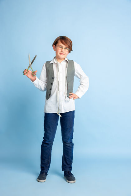 青年小男孩梦想着未来的裁缝职业童年 教育和梦想的概念衣服职业艺术家