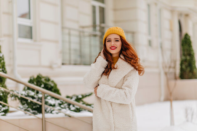 帽子穿着白大褂的可爱的白人妇女享受周末散步穿着冬装的时尚姜汁女孩的户外肖像时尚享受年轻