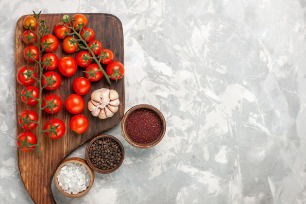 不同顶视图新鲜的樱桃西红柿和不同的调味品在浅白色的表面烹饪沙拉调味品