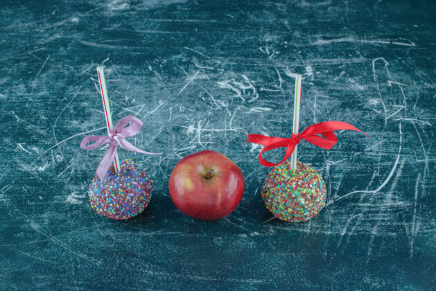 糖果糖果棒棒糖和蓝色背景上的苹果高品质的照片甜的外套新鲜的