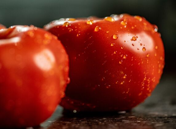 餐特写新鲜成熟的西红柿水滴在一个黑色花岗岩厨房台面自然有机柜台