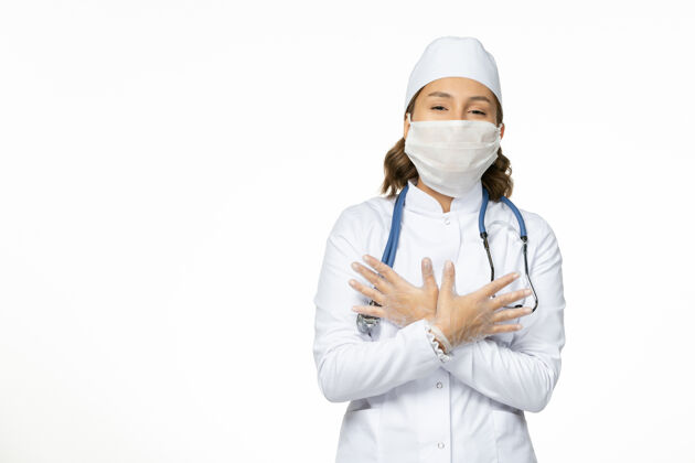 病毒正面图年轻女医生戴着无菌口罩和手套由于白色表面有冠状病毒医生制服专业