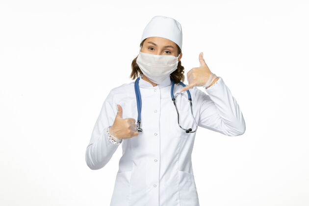 药品正面图：年轻女医生 穿着白色医疗服 白色办公桌上有冠状病毒导致的无菌口罩女性冠状病毒大流行