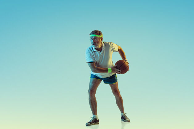 休闲高级男子在霓虹灯下的梯度背景下打篮球身材魁梧的白种人男模保持活跃 运动精神乐趣爱好设备