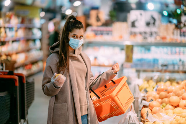 防护戴着防护面具的年轻女子购物商店购物中心病毒