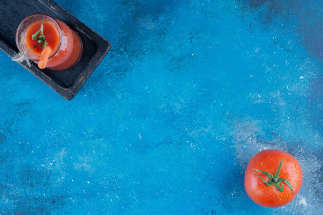 玻璃美味的番茄汁和蓝色背景上的番茄高品质的照片健康蔬菜农业