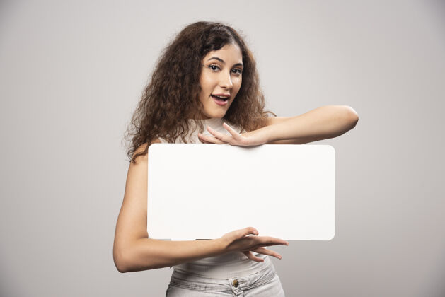 头发年轻女子举着空白的白色演讲海报高质量的照片女性脸青少年