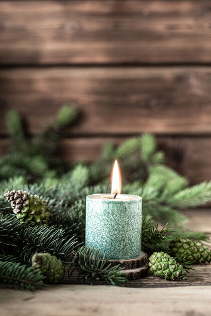雪圣诞绿色蜡烛 木桌上放着冷杉枝和松果木圣诞节日
