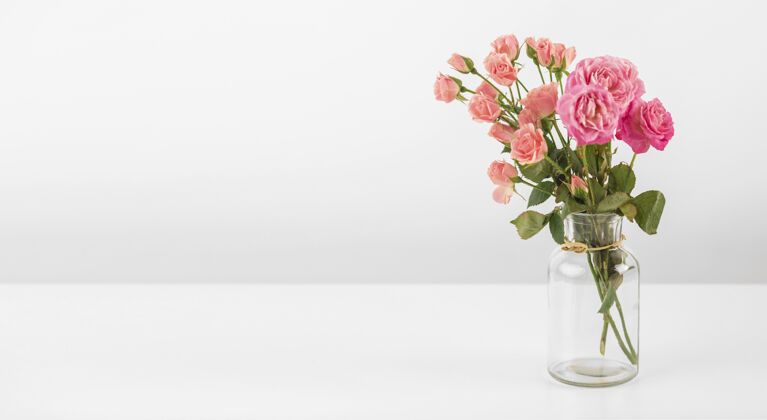 玫瑰桌上放着玫瑰花的花瓶开花罐子花瓣